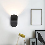 Black Nordic Glow Wall Lamp glowing on a white wall