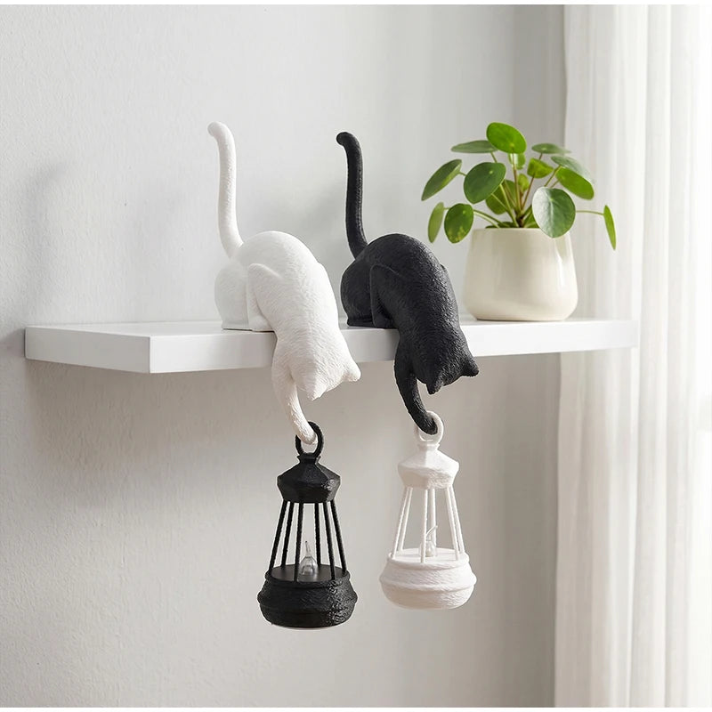White and black Gothic Cat Shelf Hook Figurines with lanterns on a white shelf