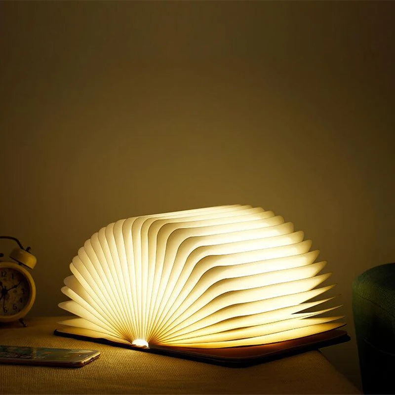 Storybook Folding Book Lamp opened wide and glowing warm white in a dark room