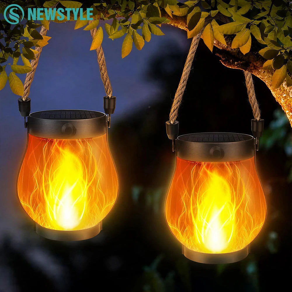 Two Solar Flickering Flame Lanterns hanging and glowing at night