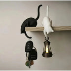 Black and white Gothic Cat Shelf Hook Figurines on a shelf holding keys and a small lantern