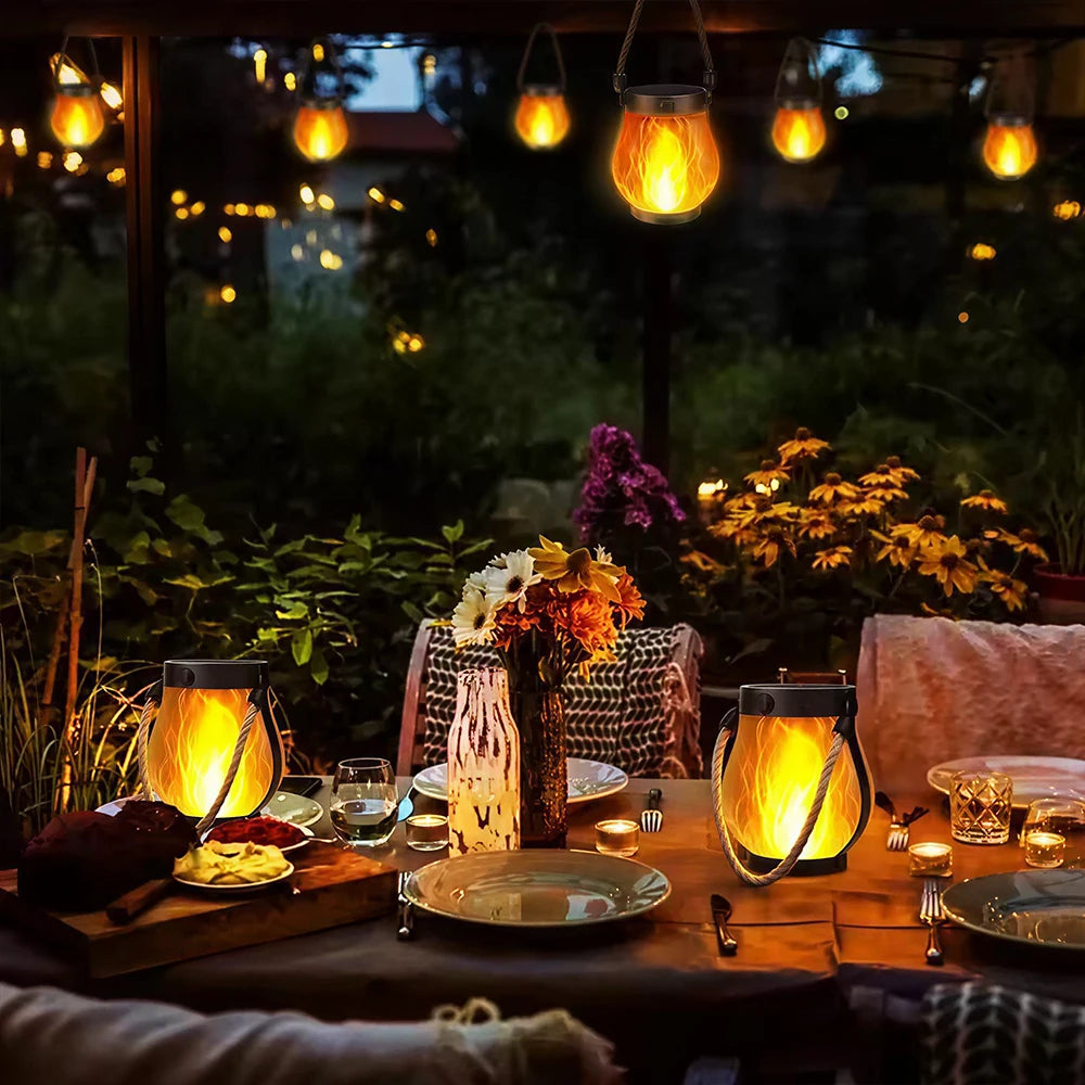 Solar Flickering Flame Lanterns hanging over a garden table at night